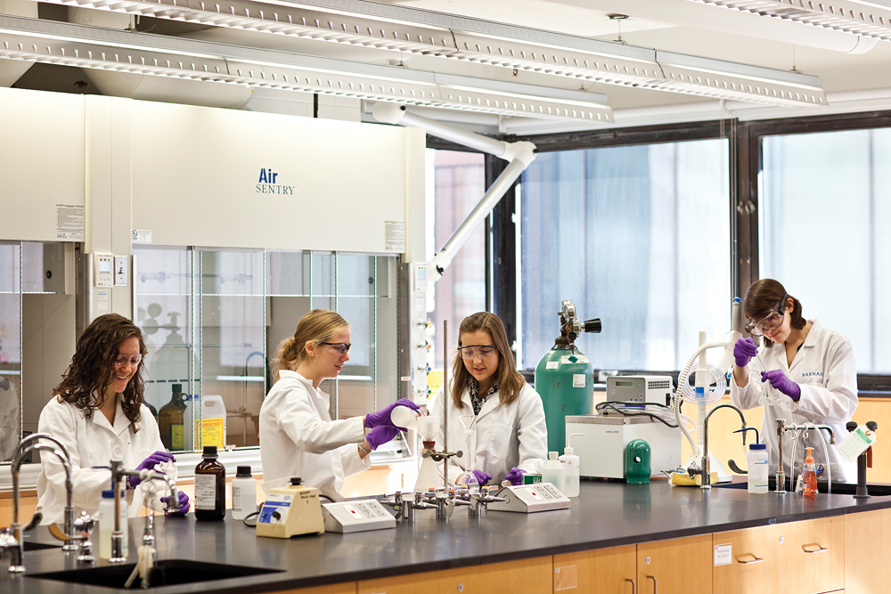 Barnard students in white lab coats in a chemistry lab